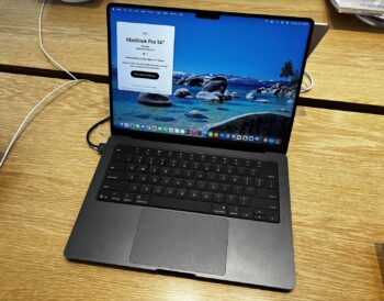 Space Black 14-inch MacBook Pro open on a wooden table