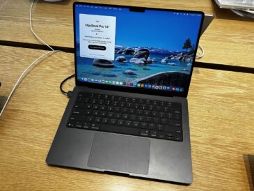 Space Black 14-inch MacBook Pro open on a wooden table