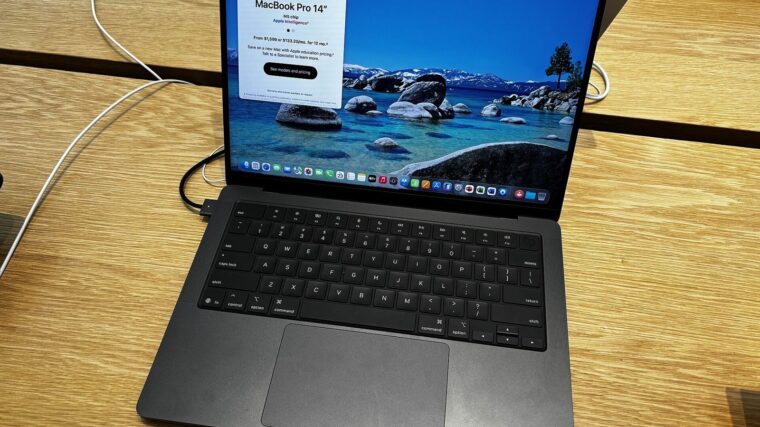 Space Black 14-inch MacBook Pro open on a wooden table