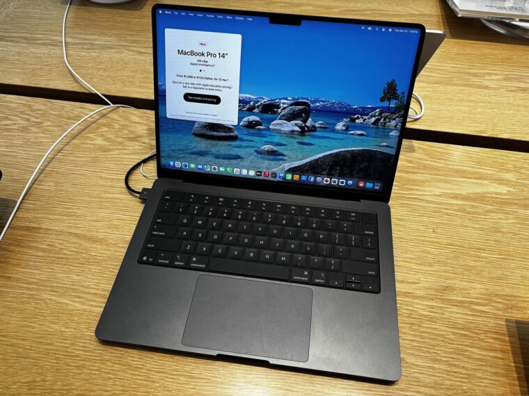Space Black 14-inch MacBook Pro open on a wooden table