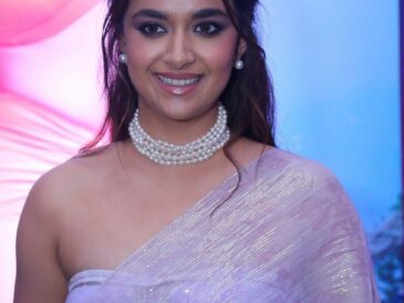 Keerthy Suresh smiling at a film event in a lavender saree