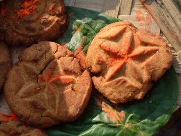 Golden thekua with pressed patterns on a leaf, prepared for Chhath Puja