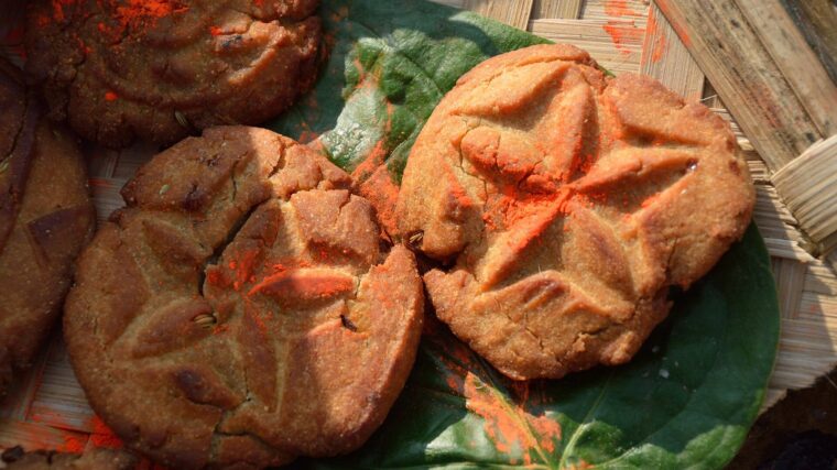 Golden thekua with pressed patterns on a leaf, prepared for Chhath Puja