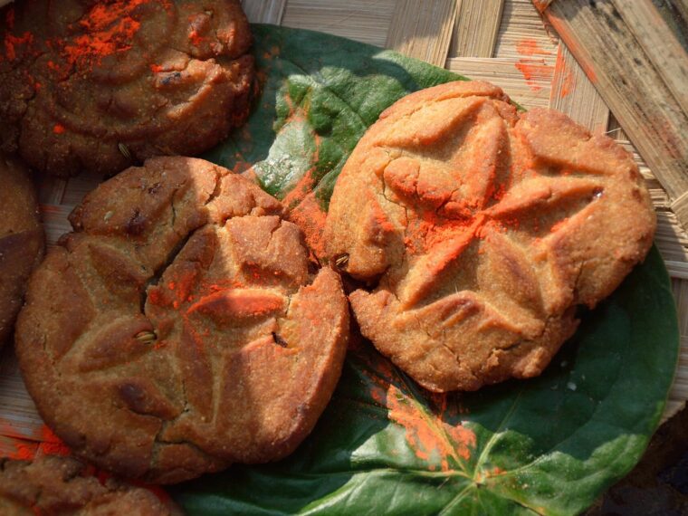 Golden thekua with pressed patterns on a leaf, prepared for Chhath Puja